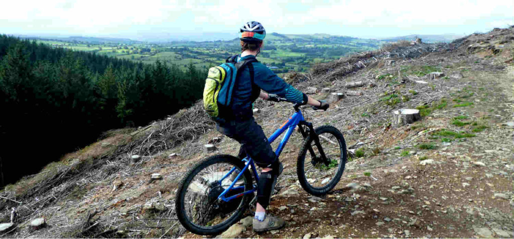 hardtail vs full suspension mountain bikes- Carolyn on a hill